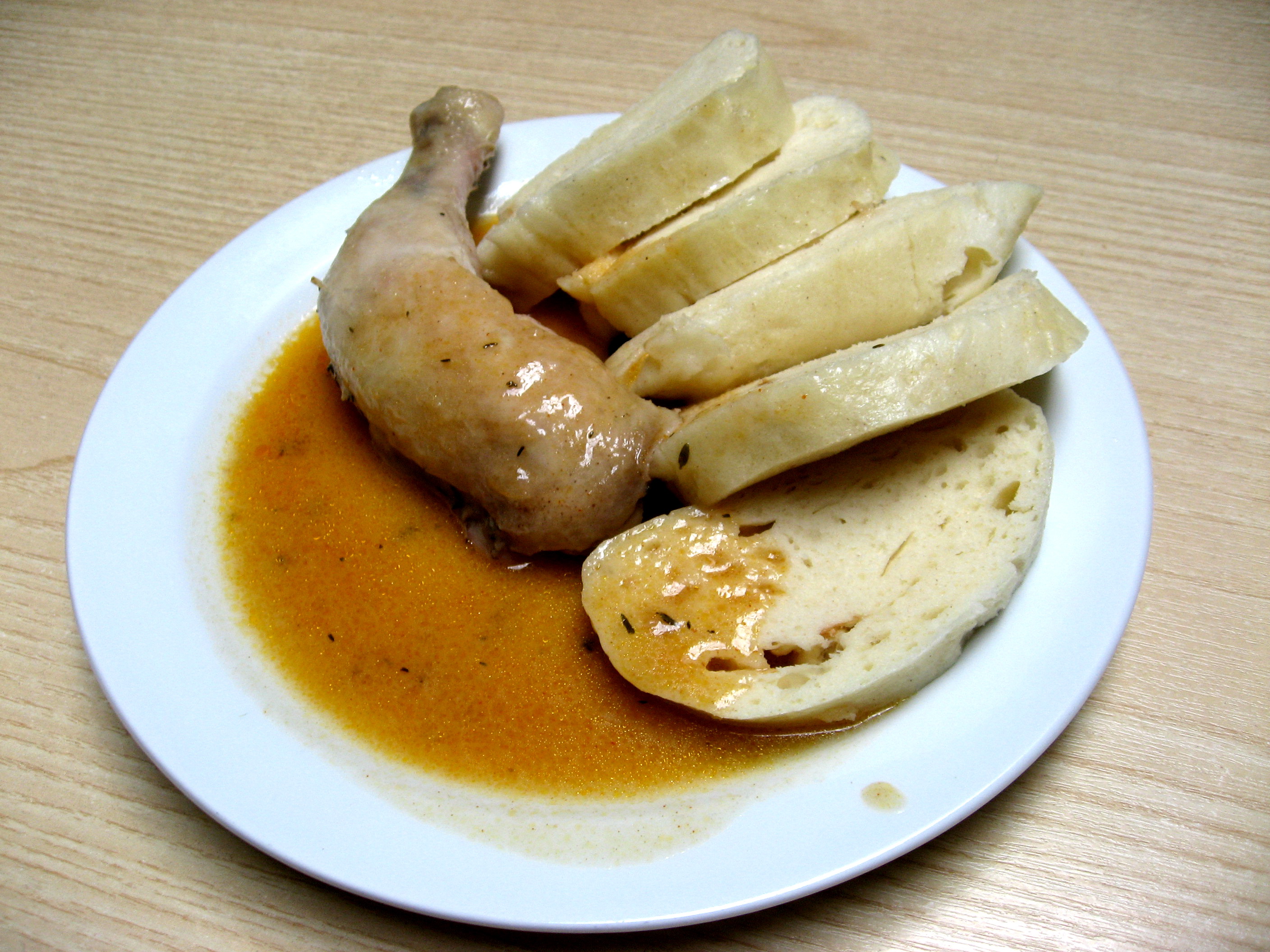 Il Houskový knedlík (Gnocco di pane semplice) in accompagnamento a un piatto di carne.