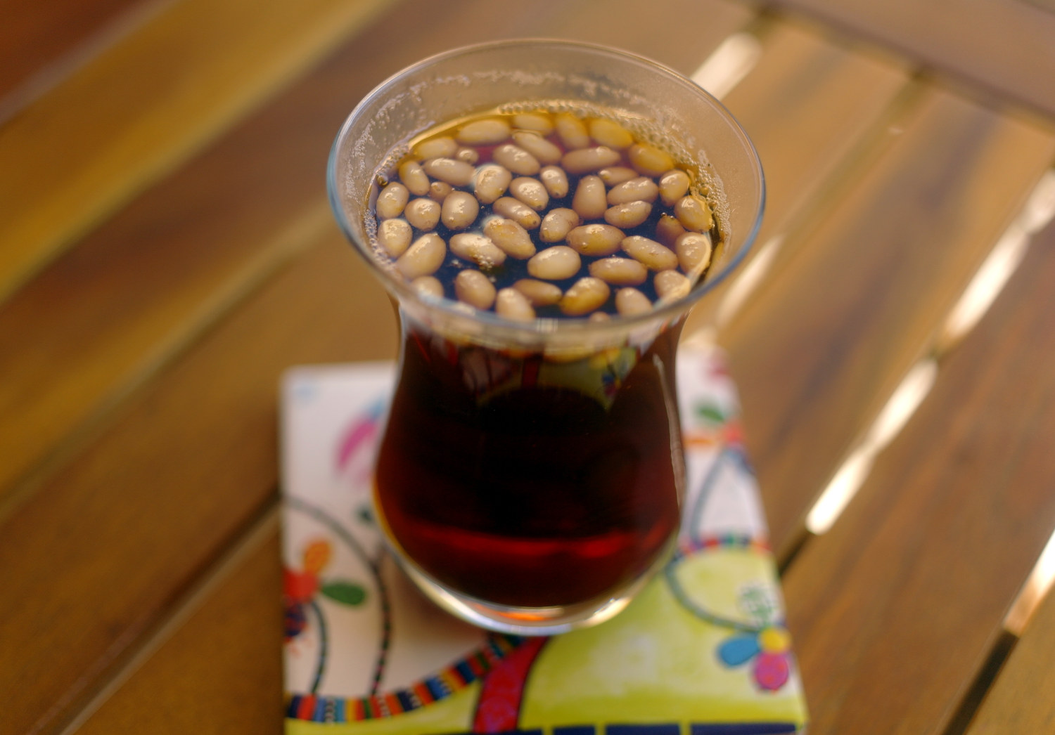 Un bicchierino di tè con menta e pinoli.